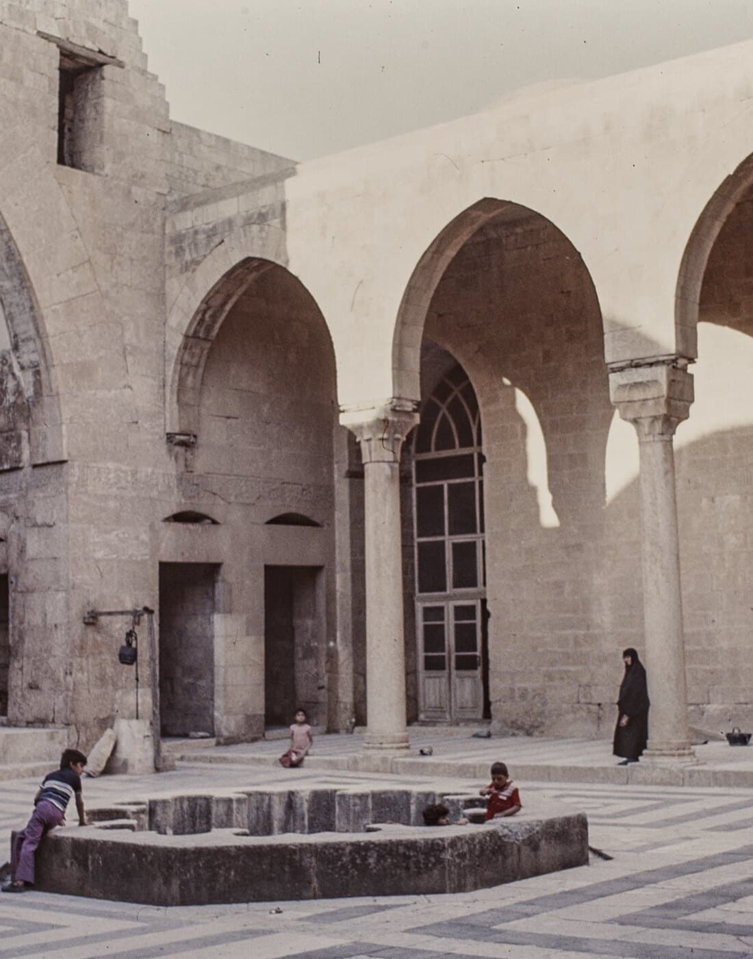 Sunlit stone arcade of a historic courtyard